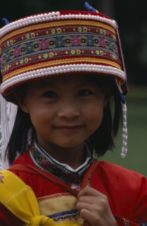 CHINA, Yunnan, "Near Kunming. Portrait of a young Sani girl at the Stone Forest, wearing a