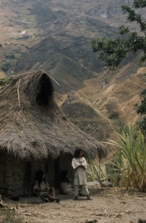 COLOMBIA, Sierra Nevada de Santa Marta, Kogi Tribe, "Young man stands outside the family home above