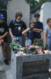 FRANCE, Ile de France, Paris, Pere Lachaise Cemetery. Visitors surrounding Jim Morrison’s Grave