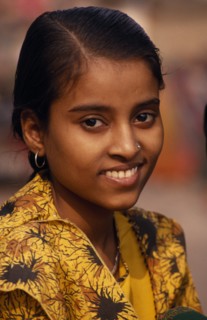 INDIA, Uttar Pradesh, Varanasi, Head and shoulders portrait of young girl on the ghats wearing a