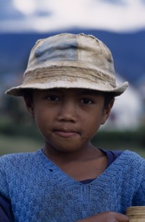 MADAGASCAR, People, children, Road to Ambositra. Portrait of a young boy wearing a dirty hat and