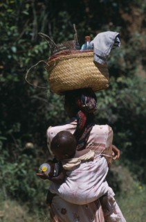 MADAGASCAR, People, Women, Near Ambositra. Portrait of a woman carrying a baby in a sling on her