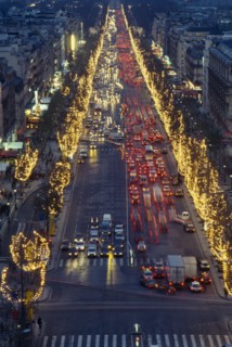 FRANCE, Ile de France, Paris, Les Champs Elysees at night with illuminated shop fronts and traffic