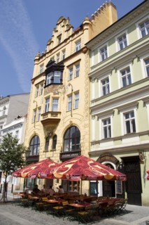 CZECH REPUBLIC, Bohemia, Prague, Tables and umbrellas on the pavement outside a cafe in a