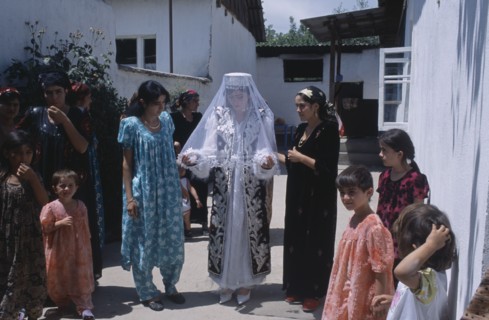 TAJIKISTAN, Wedding, "The bride wearing a veil and highly decorated jacket, surrounded by guests at