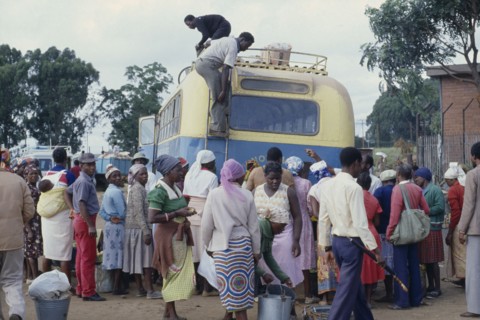 ZIMBABWE, Harare, Crowds around unloading bus.