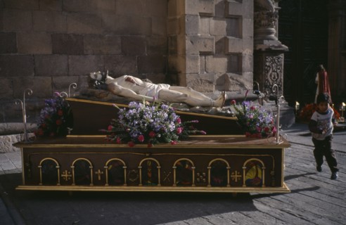 MEXICO, San Luis, Potosi, Crucified Christ lying vertically in a Easter Procession with a boy