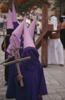 MEXICO, Oaxaca, "Young, masked penitents carrying wooden crosses during Easter parade. "