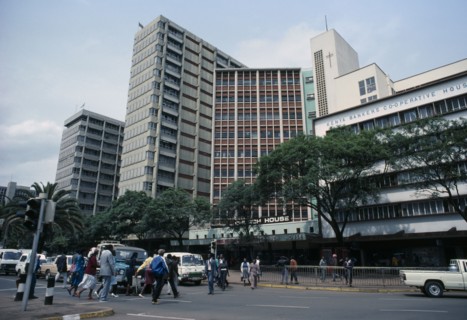 KENYA, Nairobi, "Downtown Nairobi with people crossing road, waiting traffic and high rise