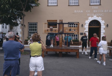 BERMUDA, St George, Tourists in kings Square with people in the foreground taking pictures of a man