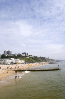 ENGLAND, Dorset, Bournemouth, The East Beach showing the seafront attractions with people on the