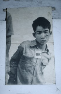 CAMBODIA, Phnom Penh, Tuol Sleng Museum. Photograph of a young male prisoner in a Khmer Rouge
