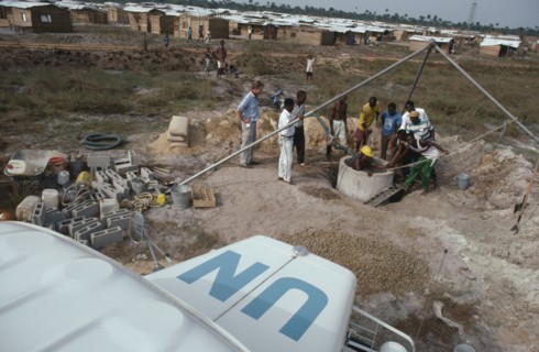 LIBERIA, War, UN peacekeeping team installing water pump and well in refugee camp for people
