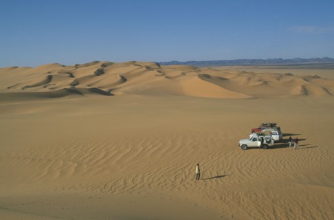 LIBYA, Sahara Desert, Tourists with four by four vehicles in desert landscape.