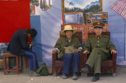 TIBET, Lhasa, "Chinese police pose in front of backdrop featuring desirable electrical goods in