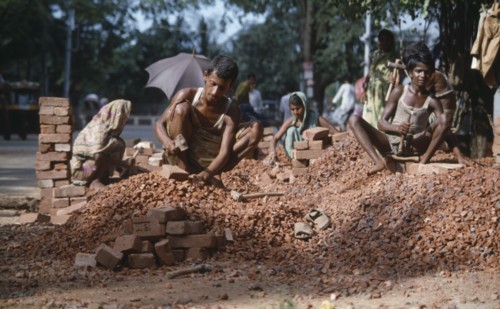 BANGLADESH, Dhaka, Men and women stone breaking with bricks and hammers