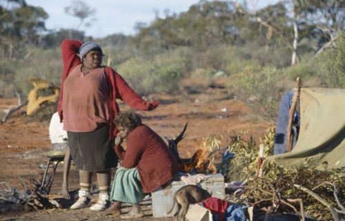 AUSTRALIA, Southern , Oak Valley, Aboriginal women in an Aborigine camp with one women stretching