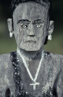 MADAGASCAR, Art, Mahafaly aloalo carved memorial post in form of human figure hung with cross