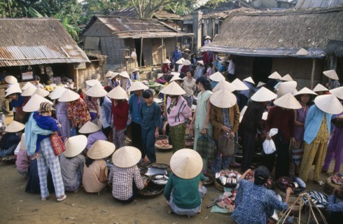 VIETNAM, Central, Hue, Village market near Mings Tomb with women wearing conical hats gathered