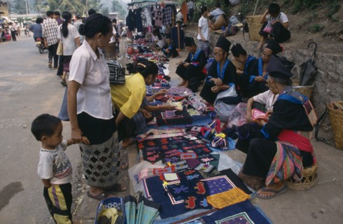 LAOS, Luang Prabang, Hmong market vendors with colourful textile stalls