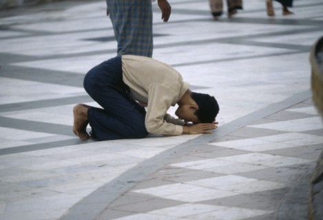 MYANMAR, Yangon, Man praying on floor at Shwedagon Pagoda