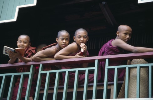 MYANMAR, Insein, Monks leaning on balcony at Ywama Monastry
