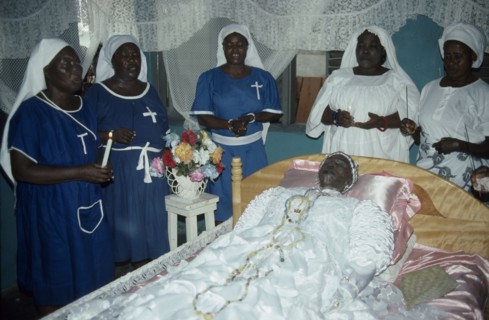 GHANA, South, Teshie, Women surround deceased Ga priestess of the sea god Kanjar laid out on bed
