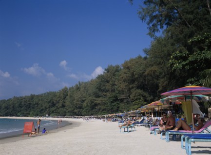 THAILAND, North Phuket, Naiyang Beach, View along the sandy beach with row of sun loungers and