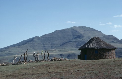 LESOTHO, Architecture, Circular straw roofed hut with mountains behind