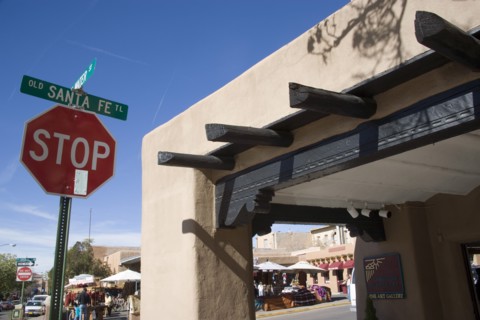 USA, New Mexico, Santa Fe, Stop sign on the Old Santa Fe Trail beside and adobe Pueblo Revival