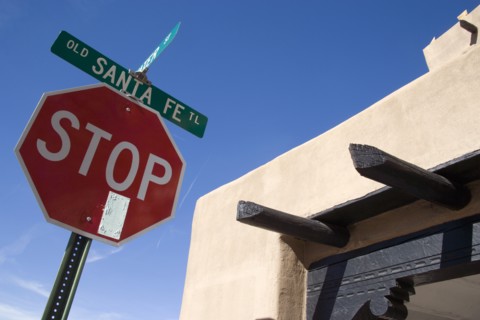 USA, New Mexico, Santa Fe, Stop sign on the Old Santa Fe Trail beside and adobe Pueblo Revival