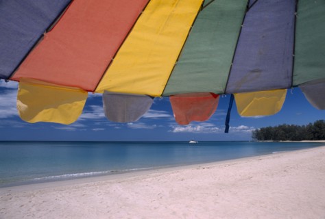 THAILAND, North Phuket, Naiyang Beach, "Close up of a multi coloured parasol on the sandy beach,