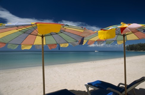 THAILAND, North Phuket, Naiyang Beach, "Two multi coloured parasols and  sun loungers on the sandy