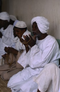 SUDAN, Religion, Dervishes praying holding prayer beads.