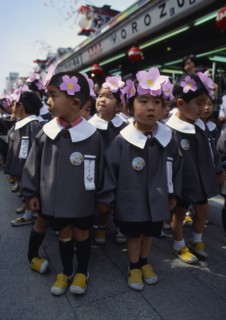 JAPAN, Honshu, Tokyo, Asakusa. Kannon Temple.Nursery school children dressed in uniforms and flower
