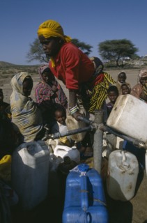 ETHIOPIA, Jijiga, Woman filling water containers at standpipe in Somali camp.