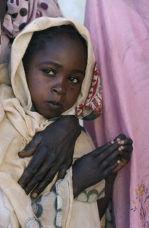 SUDAN, Asernei, Portrait of Chadian refugee girl standing beside her partly seen mother.