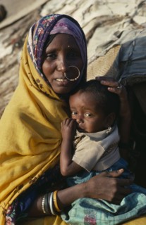SUDAN, North East, Gadem Gafriet Camp, "Portrait of Beni Amer Beja nomad woman holding child,