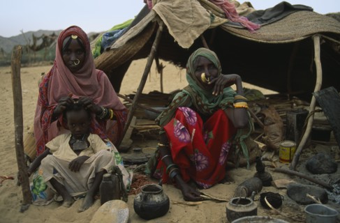 SUDAN, North East, Gadem Gafriet Camp, Beja nomad Beni Amer tribeswomen and child outside tent in