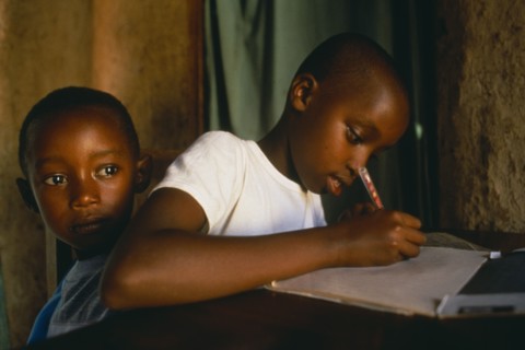 RWANDA, Akagera, "Children of Tutsi returnee family doing homework.  The family fled to Uganda over
