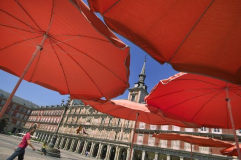 SPAIN, Madrid, "Red restaurant parasols in Plaza Mayor, Main Square."