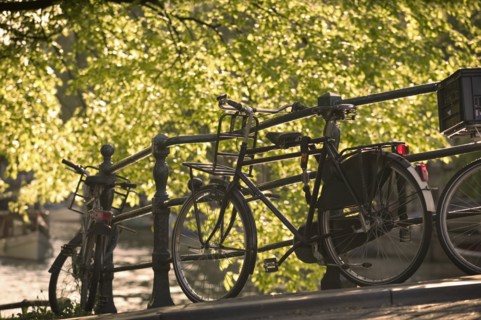 HOLLAND, North , Amsterdam, Bicycles leaning against railings on a city centre bridge.