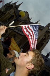 ENGLAND, London, A demonstrator waves a defaced North American flag during an anti Bush rally.