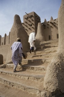 MALI, Sahel, Djenne, Two men walking up steps leading to Grand Mosque.
