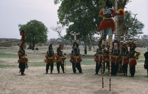 MALI, Ceremony, Dogon masked stilt dancer with others on ground below.
