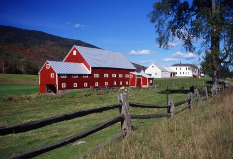 USA, New Hampshire, Colebrook, "Large red barn in a field, white farm house in the distance."