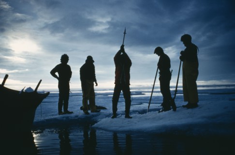 ARCTIC, Eskimos, "Silhouette of a man using an axe to cut through ice. Others stand round, two