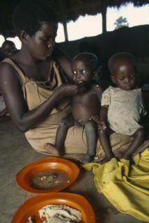 UGANDA, West Nile, Sudanese refugee mother and children at feeding centre for vulnerable people.