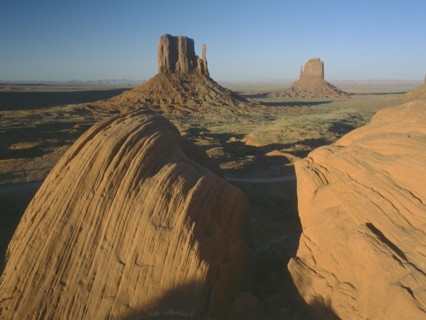 USA, Arizona, Monument Valley, Rock formations with a golden sunset glow on the valley with rocks