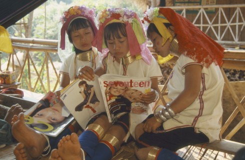 THAILAND, Chiang Rai, "Portrait of young Paduang girls in costume, reading a magazine, long neck,